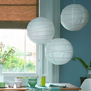 dining table near window with rice paper lampshade