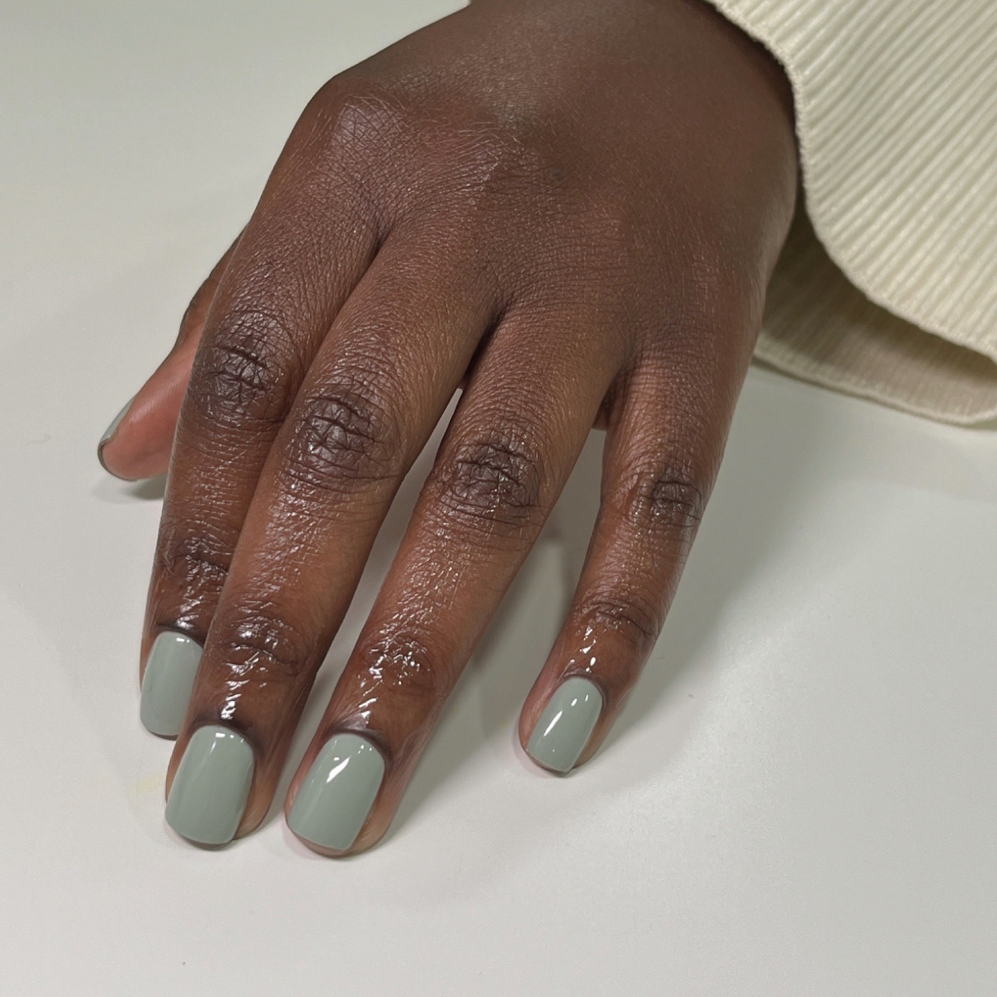A close-up of a light green manicure