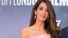 A HEADSHOT OF AMAL CLOONEY WEARING SPARKLY EARRINGS