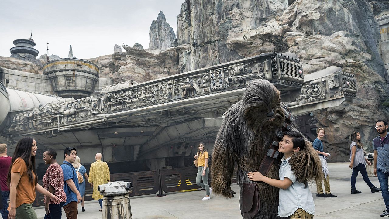 Chewbacca con invitados de Disneyland frente al Halcón Milenario