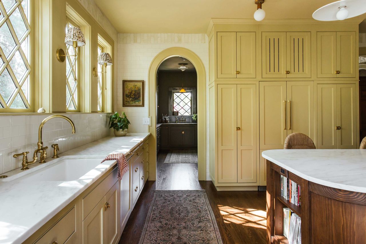 a yellow kitchen with ventilated cabinets