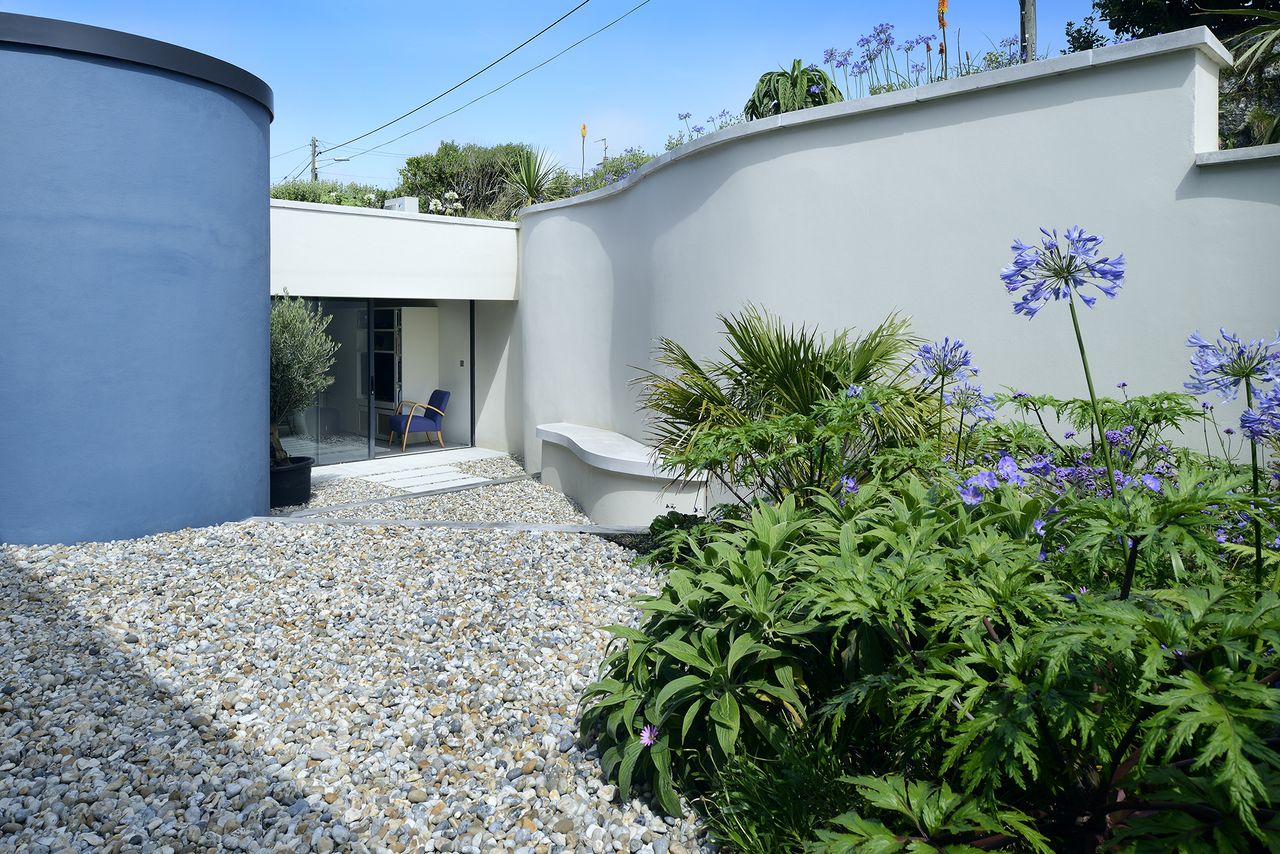 gravel path leading to front door with blue and white walls