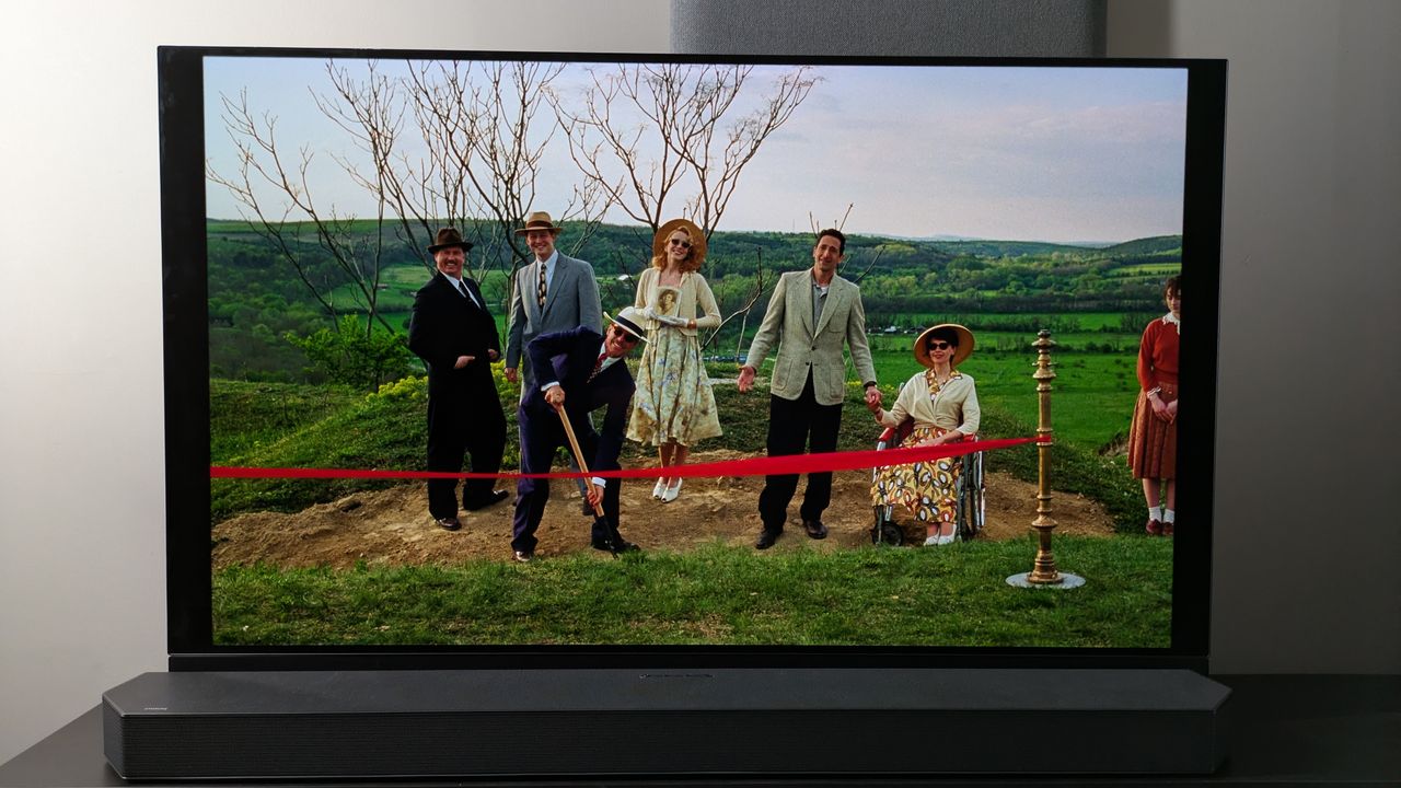 Panasonic OLED showing The Brutalist scene with family at construction site opening