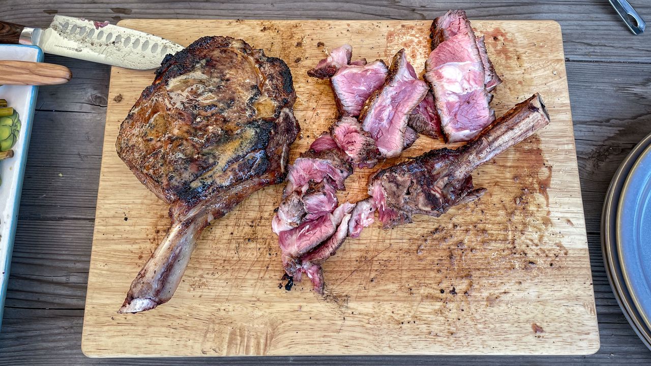 The finished steak, cut up on a wooden chopping board