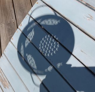 A colander with round holes provided a good view of the eclipse projected through it.