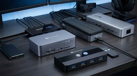 A selection of KVM switches and docking stations on a black desk