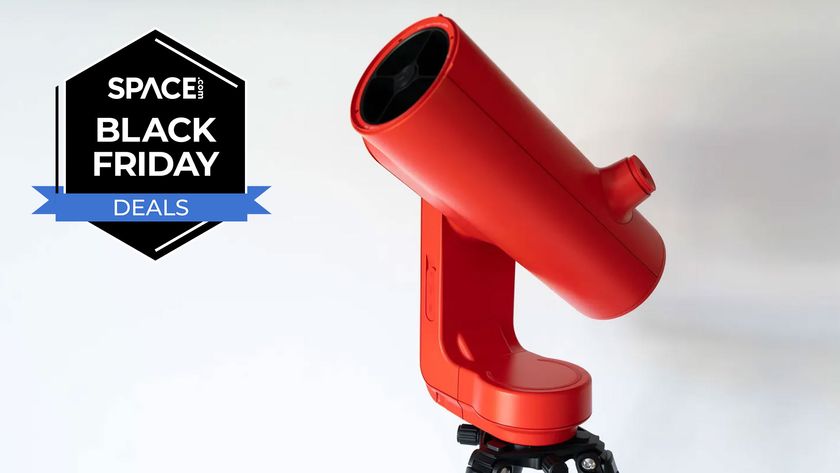 The Unistellar Odyssey Pro smart telescope in red on a white background with a Space.com Black Friday deals badge in black and blue.