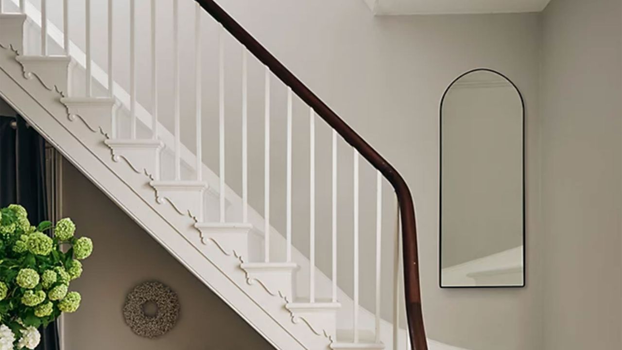 Staircase with arch mirror on wall