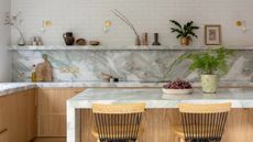 a kitchen with marble counters and backsplash, and timber cabinets