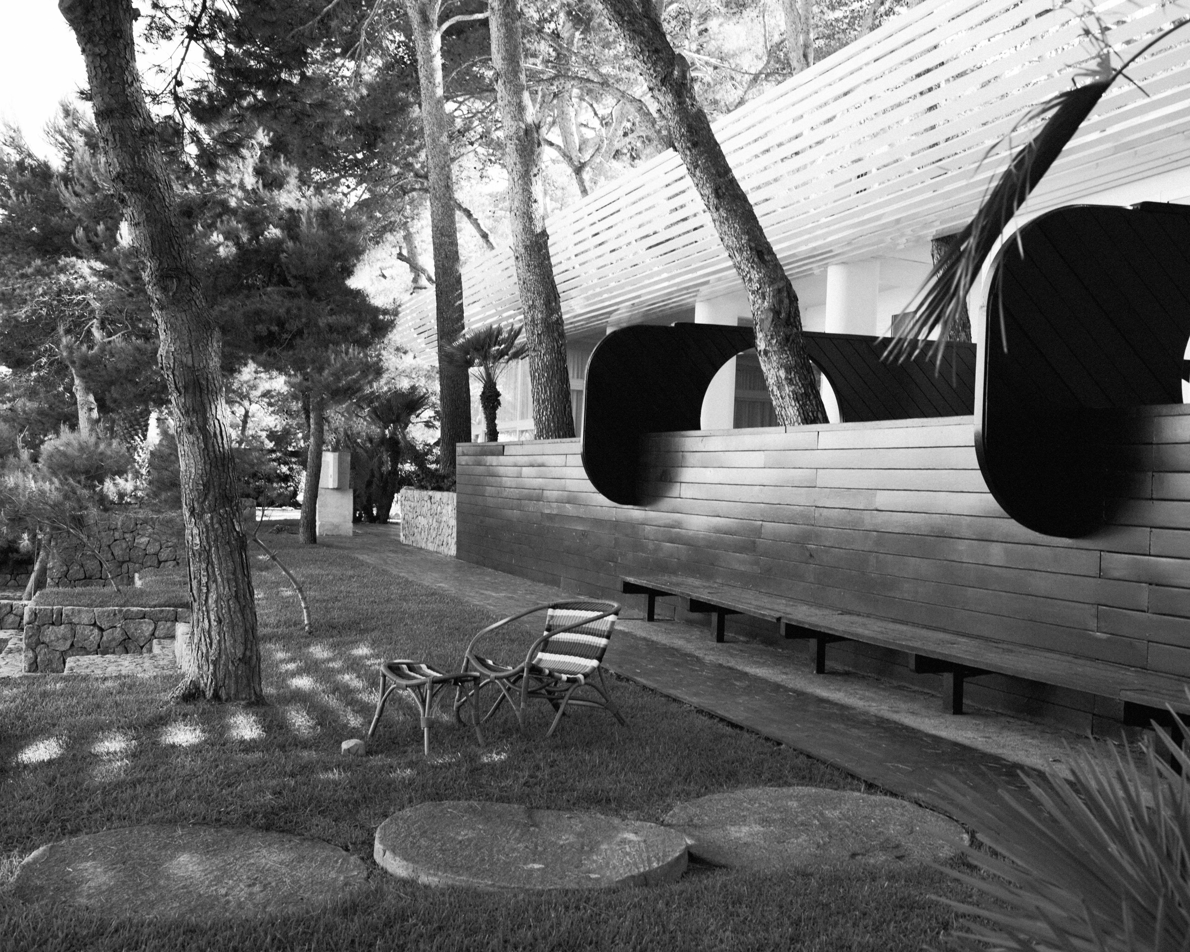 black and white shot of rattan chair in mid-century garden