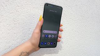 Realme GT 2 Pro review: hand with yellow nails holding a phone