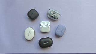 The AirPods 4 surrounded by several wireless earbuds