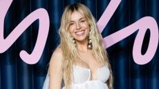 Image of Sienna Miller smiling with waving long blonde hair and wearing a white dress