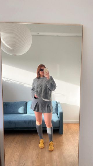 Woman wearing miniskirt with sneakers trend