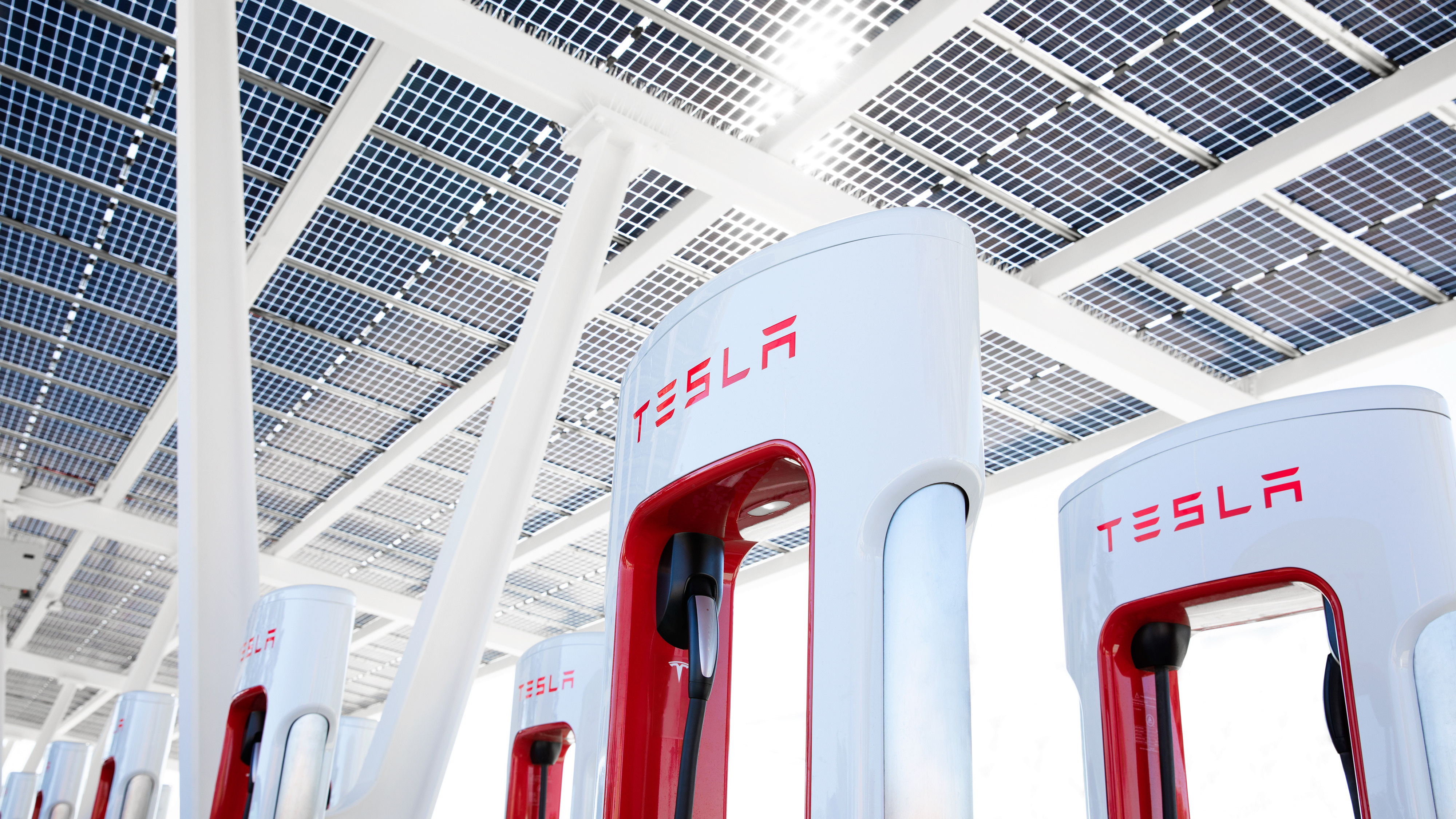 An angled shot looking up at the top section of a Tesla Supercharger