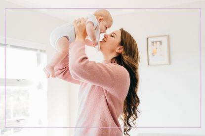 Smiling mother holding her baby in the air