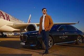 Man in sunglasses walking from an electric car to an airplane