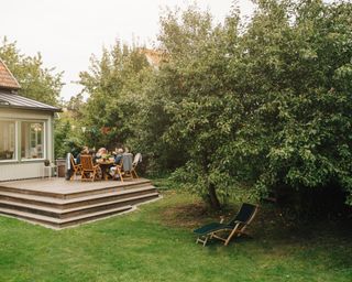 Garden dinner for friends on raised patio in private garden