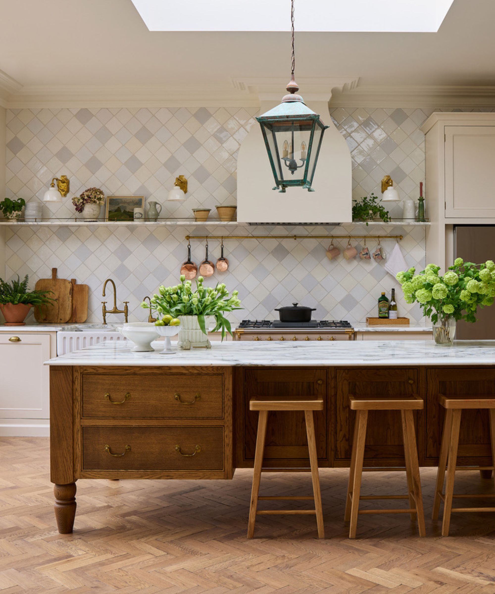 A large neutral kitchen with warm white cabinets, a wooden freestanding island, and open shelving on the walls