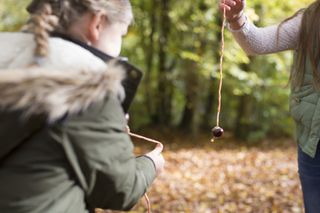 Two girls playing conkers