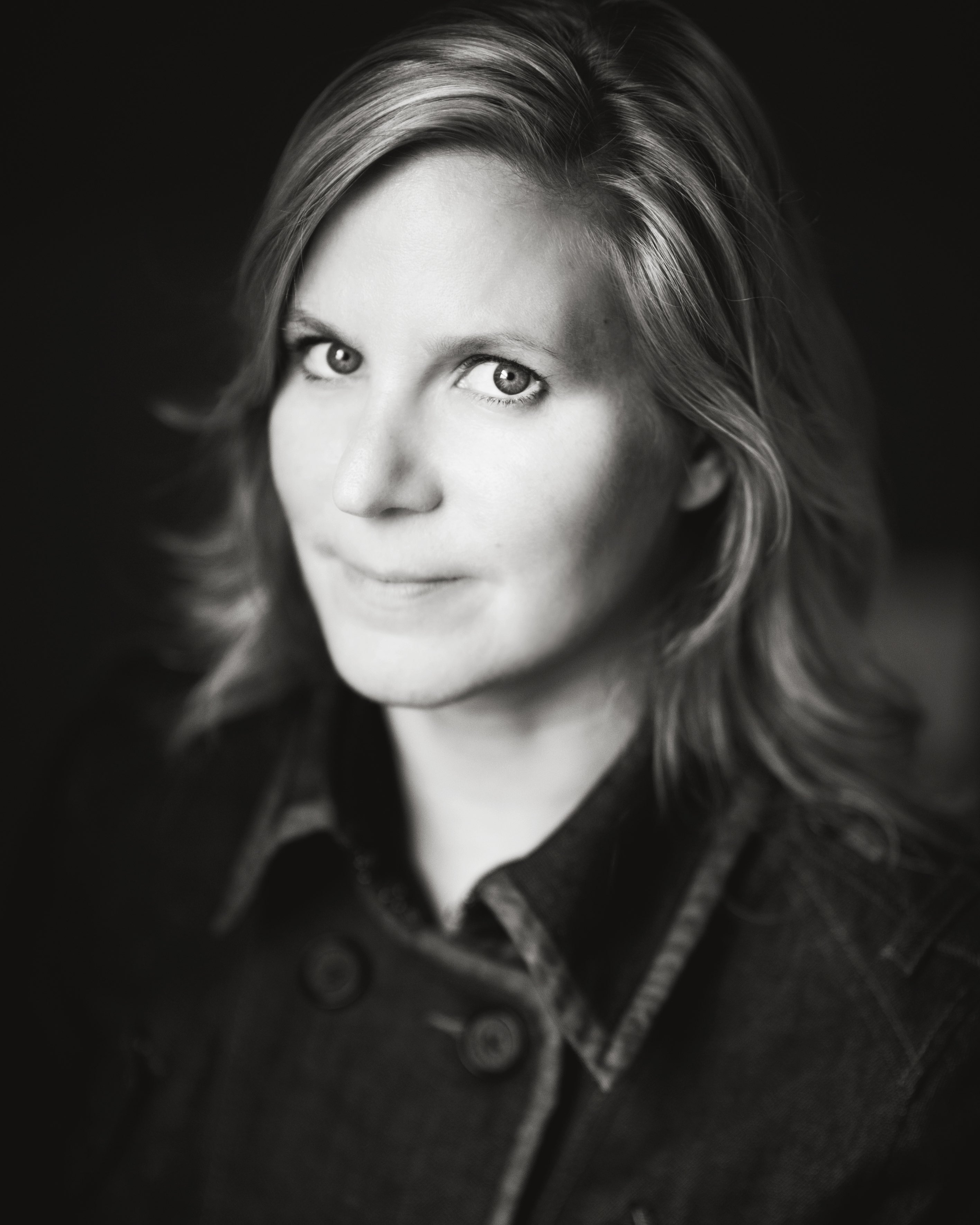 director ivy meeropol poses in a black and white headshot wearing a buttoned up jacket