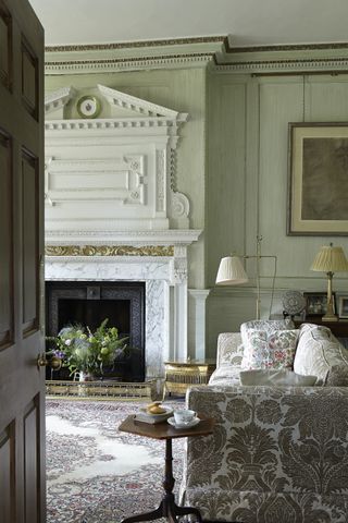 living_room_with_sofa_ornate_fireplace_and_cushions