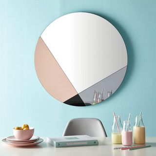 geometric mirror with blush pink and book on table