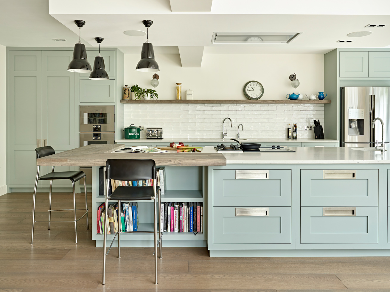 light blue open plan kitchen with wooden floor