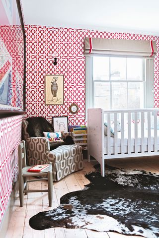 a nursery with pink patterned wallpaper