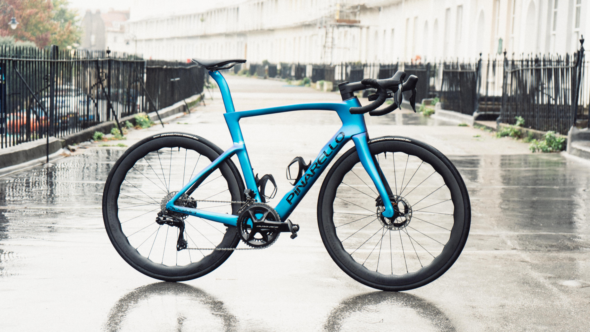 A blue Pinarello Dogma F stood on a crescent of houses