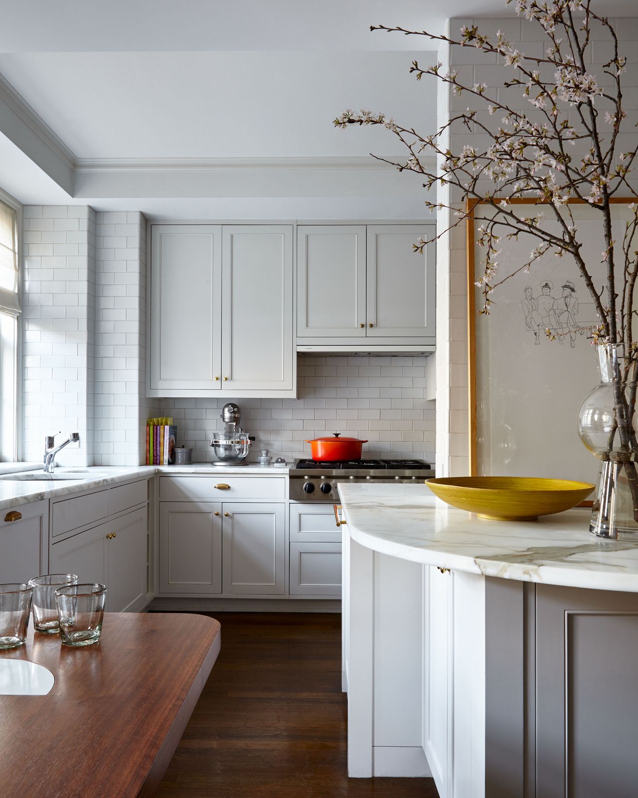 small kitchen with curvy marble countertop white units and dark wood floor