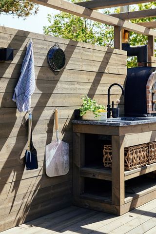 an outdoor kitchen with wall hooks for storage