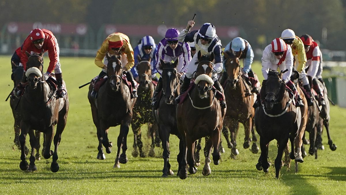 Horses and riders competing in the Prix de l&#039;Arc de Triomphe at Longchamp