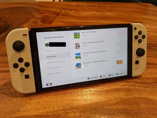 Switch on desk showing screenshot of how to redownload your games from your account profile on the eShop.