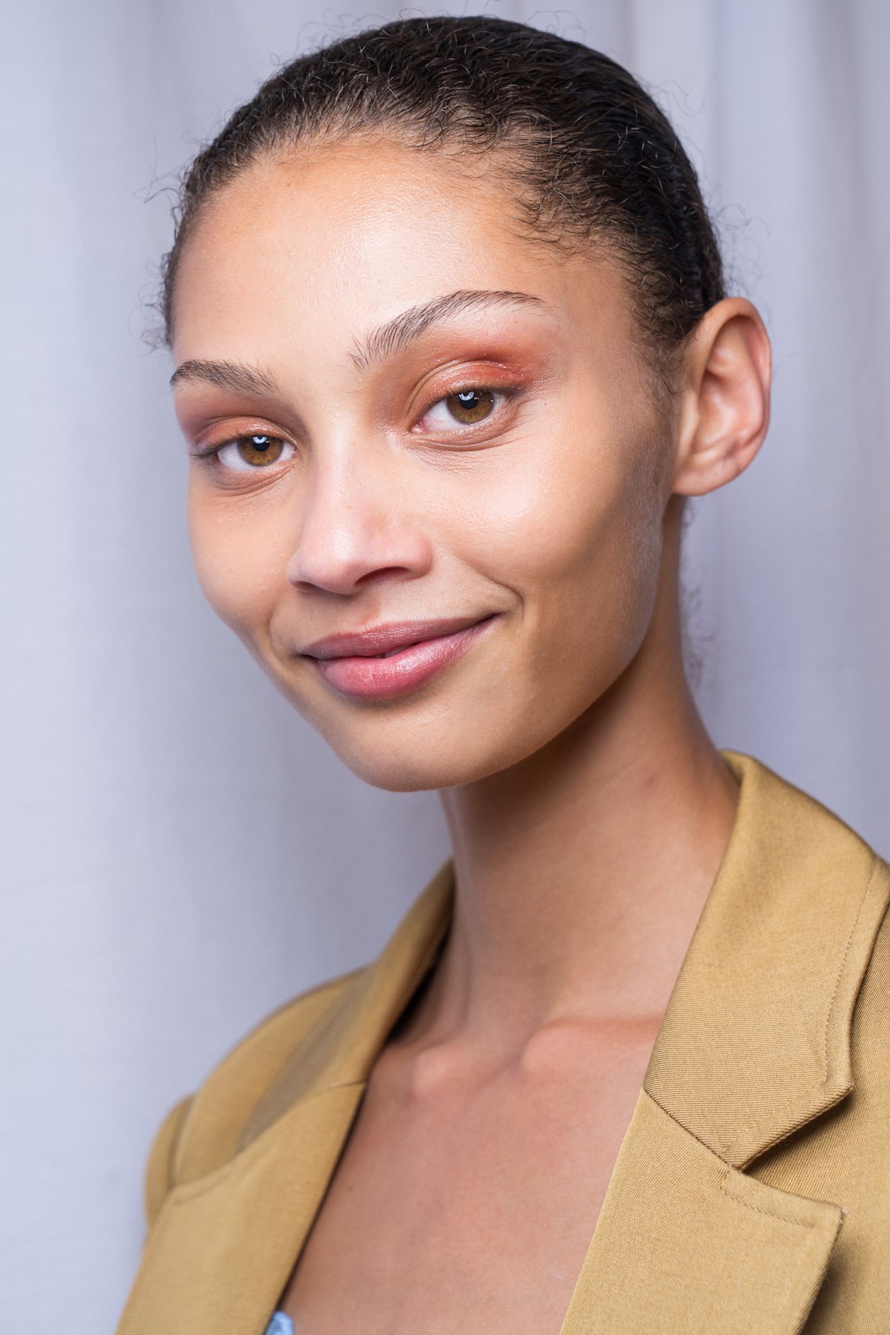 Lipgloss lids on a model in a yellow blazer at Ulla Johnson.