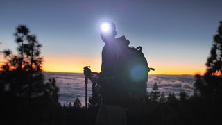 Silhouette of man hiking with headlamp