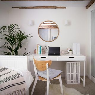 home office with white wall and round mirrir and white desk and chair