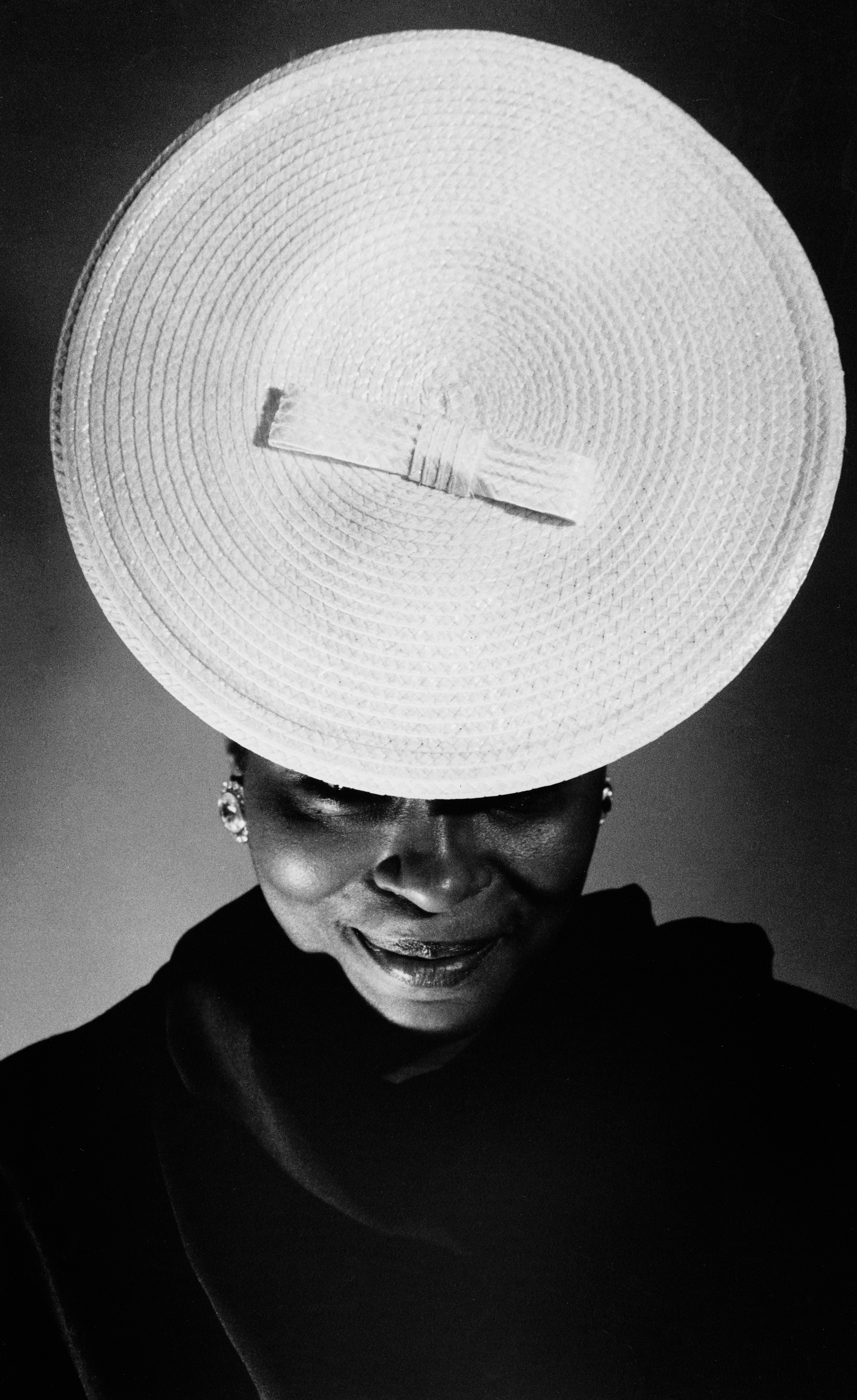 Coreen Simpson photograph of woman with round hat on head, tilted forwards