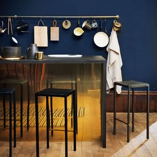 dark blue kitchen with brass panel