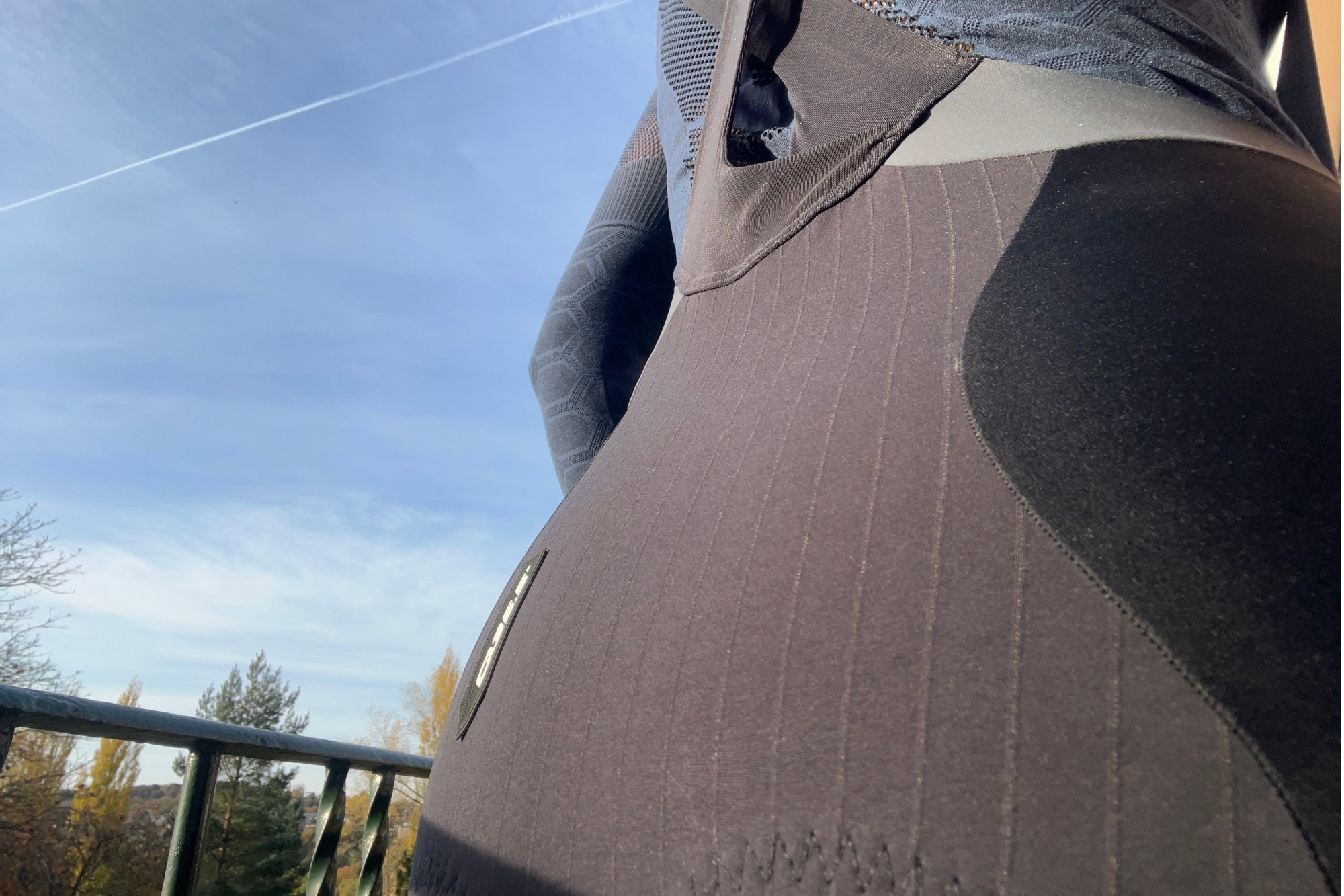 The Q36.5 Light bib tights shown close up of the fabric at the back of the tights, with blue sky to the left of the image.