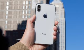 iPhone X in hand with the back facing the camera