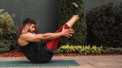 Man doing Pilates workout outside on yoga mat