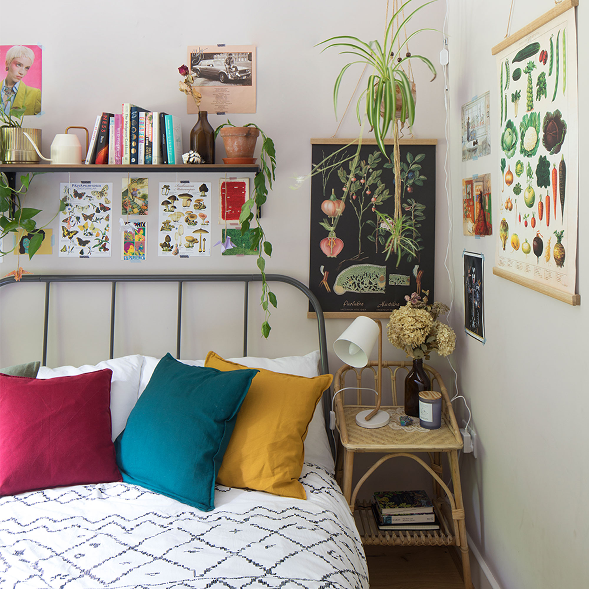 white bedroom with black bed and floral posters