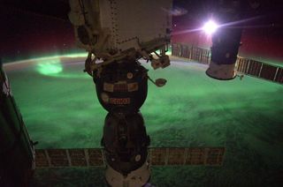 The moon shines to the left of a Soyuz capsule in this image of auroras below the International Space Station posted by Alexander Gerst on Sept. 3, 2014.
