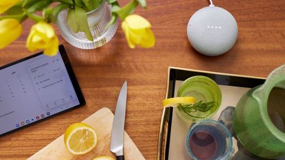 wooden worksurfae with smart speaker, tablet and wooden chopping board placed on it