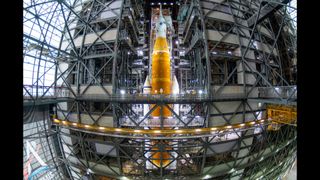 NASA's Space Launch System rocket with the Orion space capsule atop inside the Vehicle Assembly Building at Kennedy Space Center.