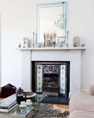 white living room with large mirror over a fireplace