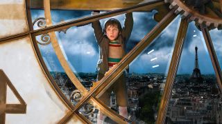 Hugo (Asa Butterfield) hangs from a clock in Hugo.