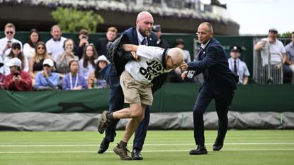 A Just Stop Oil protester being escorted off court 18 at Wimbledon after disrupting a match