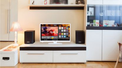 A Bush HD READY Smart TV on a white TV console in a living room